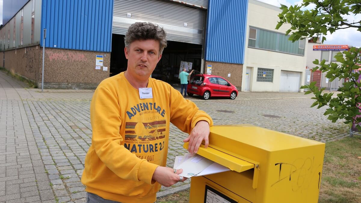  Thorsten Höller verschickt Pride-Merch Briefsendung. Er wirf in 6 Breife in einen Briefkasten.